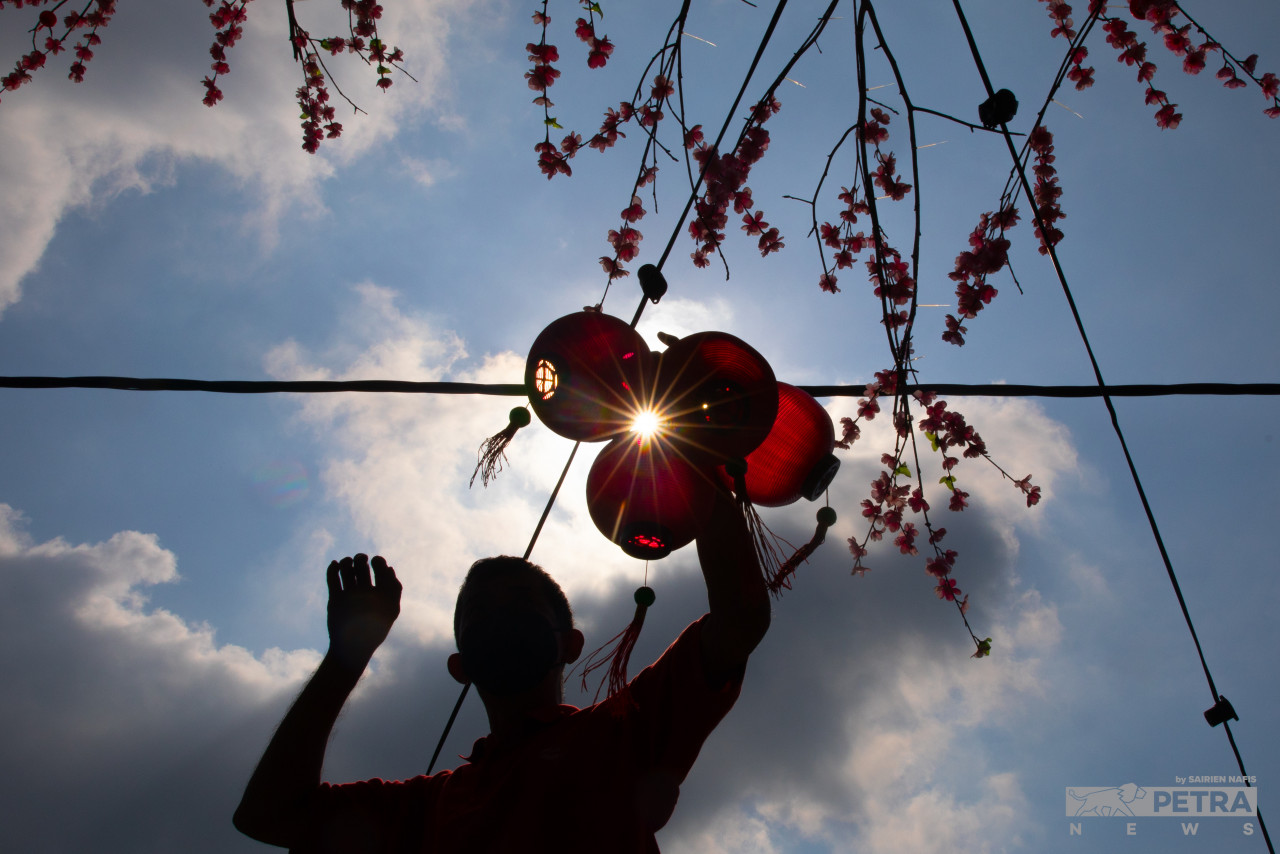A Pulau Ketam village committee member arranges lanterns around the fishing village in Port Klang in preparation for Chinese New Year tomorrow. – SAIRIEN NAFIS/The Vibes pic, January 31, 2022