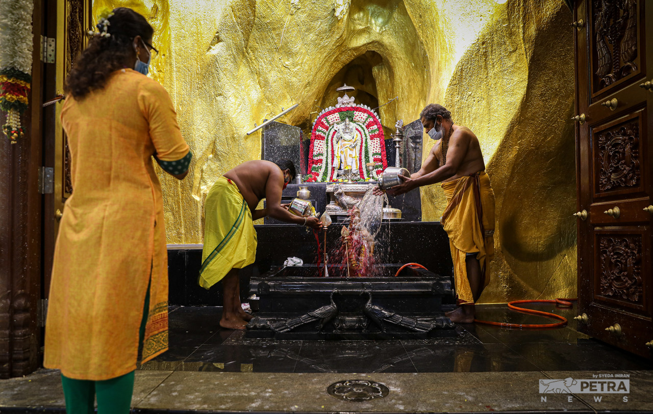 Milk brought up to the limestone cave temple by devotees is poured on a statue of Murugan. – SYEDA IMRAN/The Vibes pic, January 18, 2022