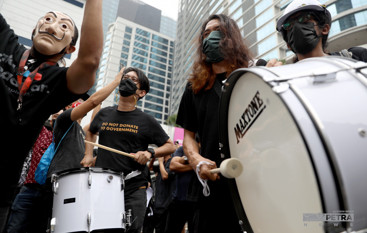 The organiser of the rally, Adam Adli (second from left), hitting the drum to lift the spirits of the protesters at Bangsar LRT station. – SYEDA IMRAN/The Vibes pic, January 23, 2022