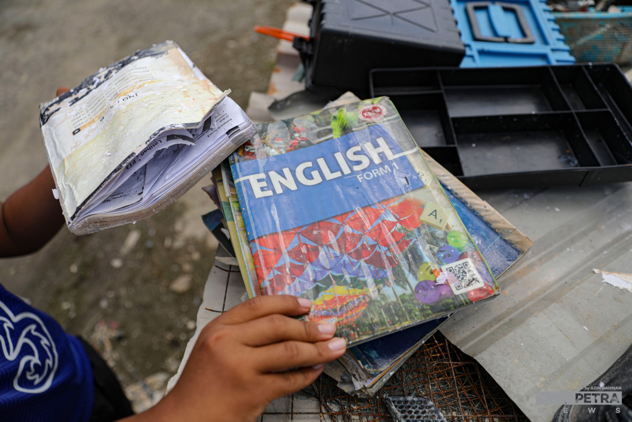 Students sift through the wreckage, evaluating the floods’ damage to schooling items such as uniforms, bags and textbooks. – AZIM RAHMAN/The Vibes pic, January 17, 2022