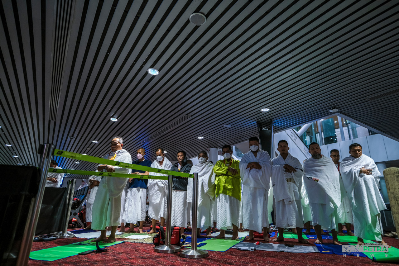 Pilgrims perform the Subuh prayer before boarding a plane to Jeddah. – ABD RAZAK LATIF/The Vibes pic, July 5, 2022