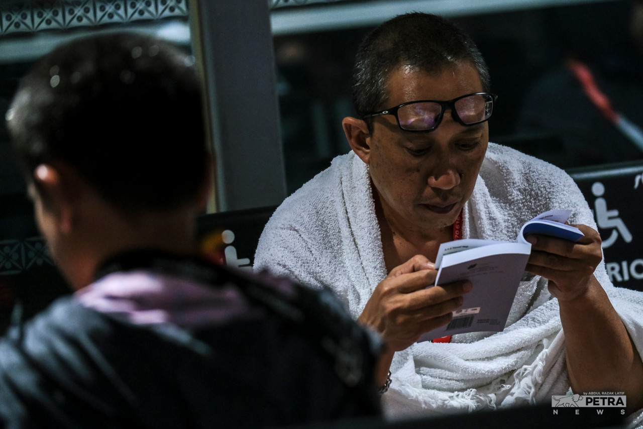 Pilgrims studying the Haj guidebook before leaving for Jeddah, not wasting any time by being idle. – ABD RAZAK LATIF/The Vibes pic, July 5, 2022