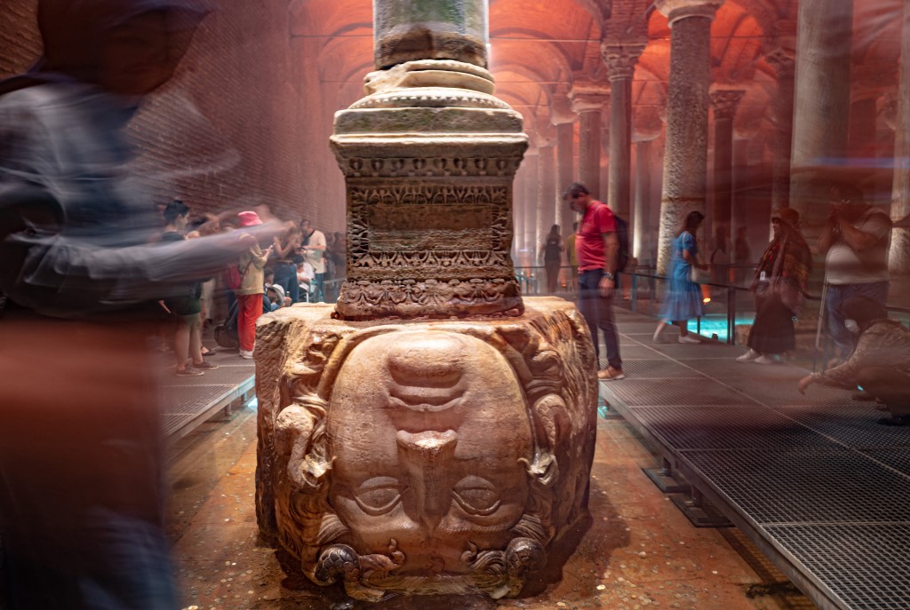People standing next to the Medusa head in the Basilica Cistern while visiting the historic site in Istanbul, Turkey, on July 26, 2022. – AFP pic