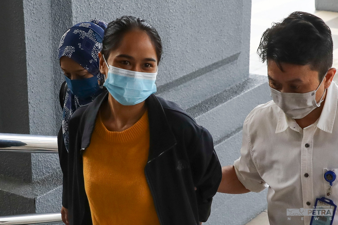 Pictured is Siti Nuramira Abdullah seen being escorted by two police officers in plain clothing to attend court proceedings. She is accused of inciting religious disharmony during her open mic skit at the Crackhouse Comedy Club and has pleaded not guilty to the charges. Nuramira and her partner, Alexander Navin Vijayachandran, are currently appealing to the public for financial aid to make bail. – AZIM RAHMAN/The Vibes pic