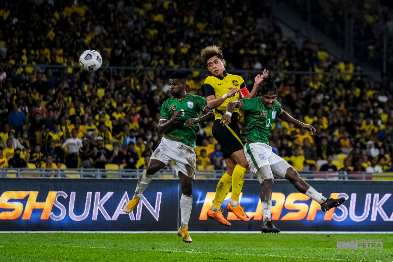 The captain, Muhammad Syafiq Ahmad heads the ball while being pushed by two Bangladeshi players in the Group E match last Tuesday. – ABD. RAZAK LATIF/The Vibes pic, June 17, 2022