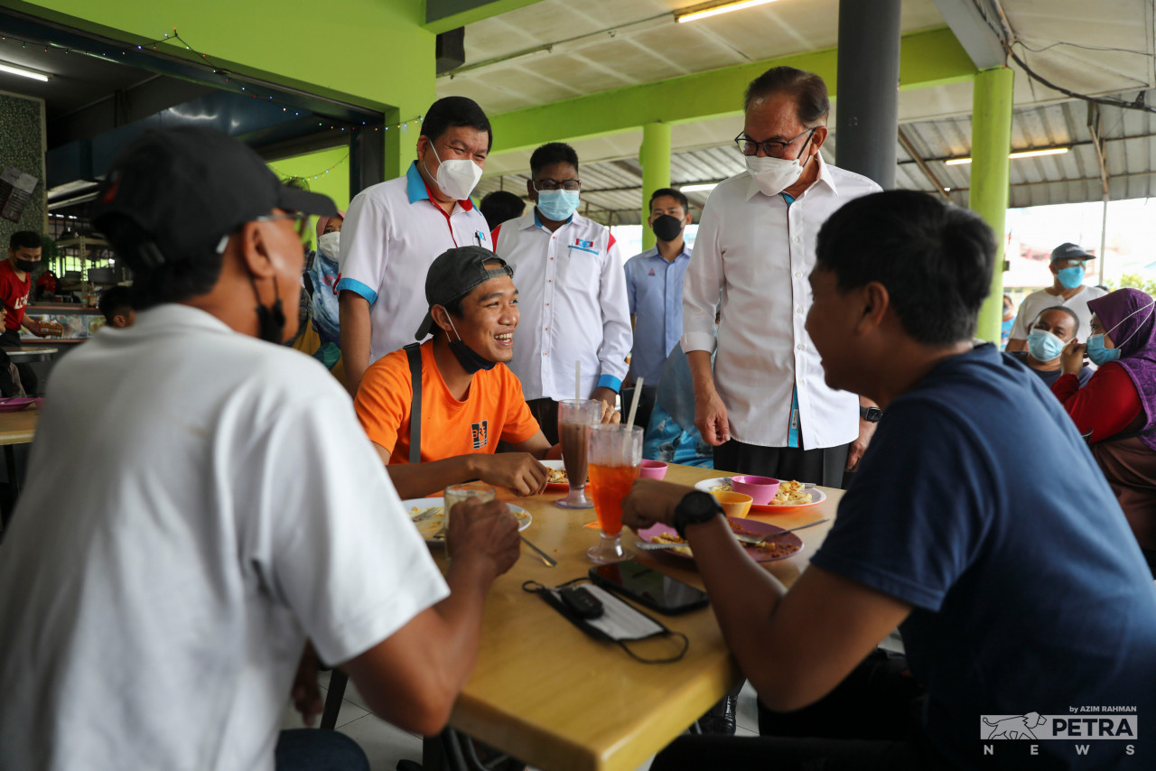 PKR president Datuk Seri Anwar Ibrahim accompanied by PKR candidate for the Tiram state seat, S. Gopalakrishnan (centre) meet the crowd at Warong Sungai Tiram food stall. – AZIM RAHMAN/The Vibes pic, March 10, 2022 