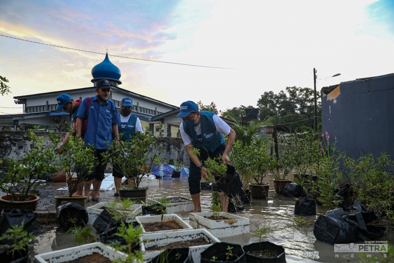 Perikatan Nasional candidate for the Larkin state seat, Zulkifli Bujang helps lift trees affected by floods while campaigning at Surau Ar-Rahman, Kg Larkin Lama. – AZIM RAHMAN/The Vibes pic, March 10, 2022 