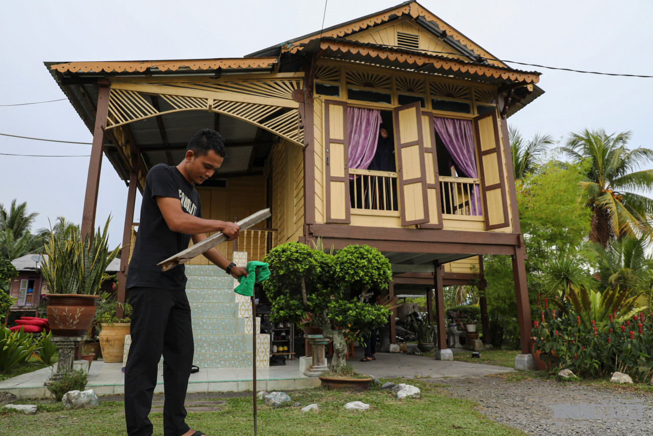 Afiq Ibtisam Tabri helps his family install kerosene lamps to light up the coming festivities. – AZIM RAHMAN/The Vibes pic, May 2, 2022