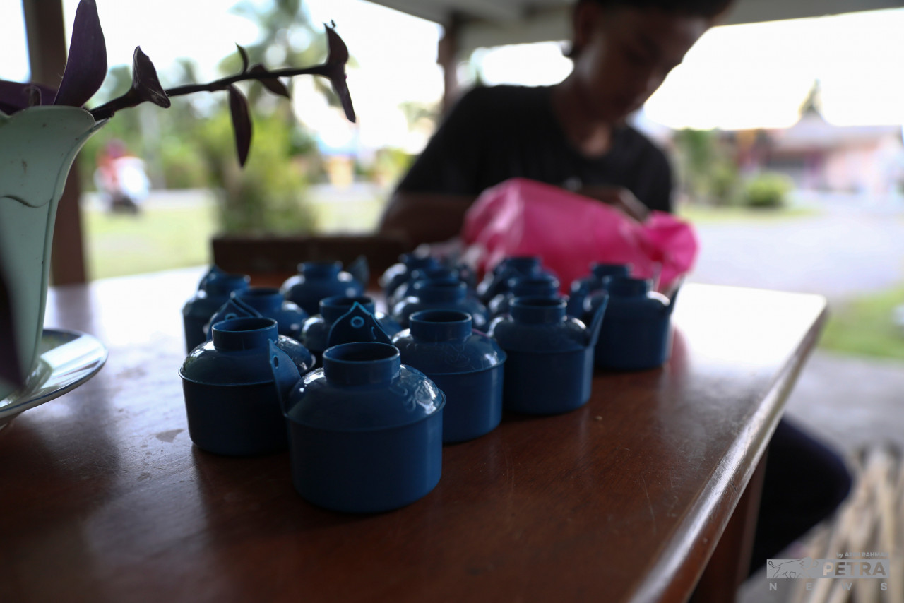 The Tabri family engages in the time-honoured Aidilfitri tradition of installing kerosene lamps. – AZIM RAHMAN/The Vibes pic, May 2, 2022