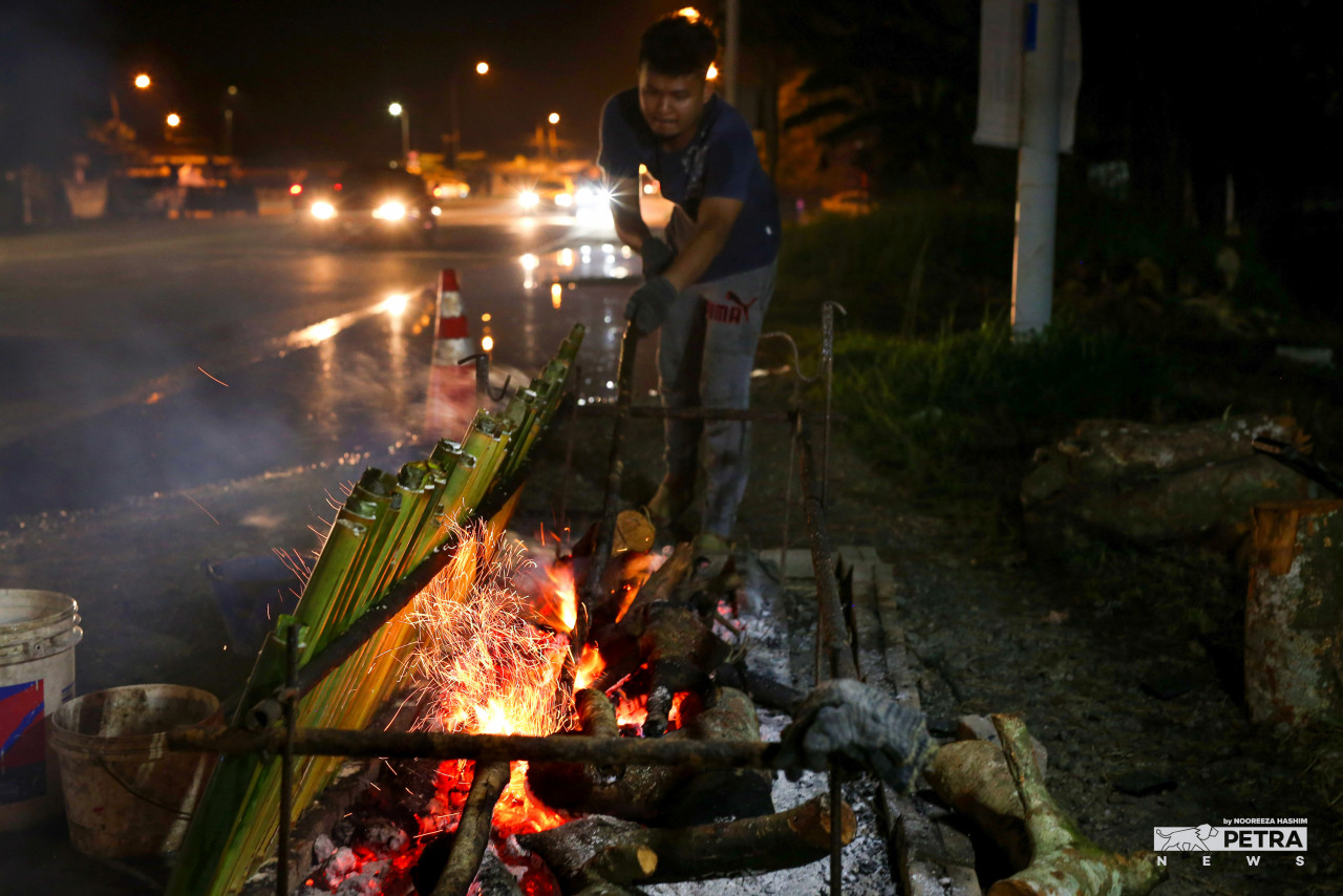 Sazwan Mohd Fauzi, who operates Lemang Kg Bahagia in Teluk Intan, grills lemang to sell during the Hari Raya festive season. – NOOREEZA HASHIM/The Vibes pic, May 9, 2022