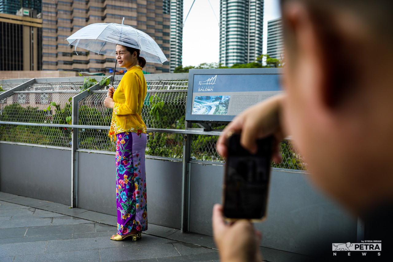 Carina Yao, wearing a baju kebaya, celebrates the Hari Raya Aidilfitri holiday by visiting the Saloma Bridge in Kuala Lumpur with her husband, Ben Liew. – SYEDA IMRAN/The Vibes pic, May 10, 2022