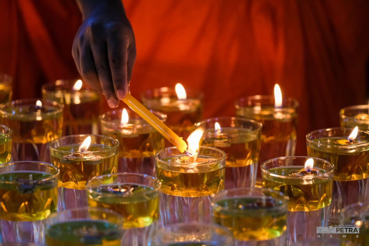A Sri Lankan priest at the Buddhist Maha Vihara temple in Brickfields lighting up oil lamps. – ABDUL RAZAK LATIF/The Vibes pic