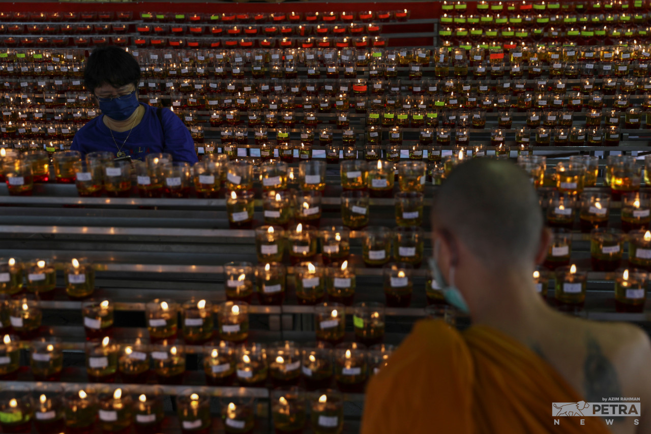 (Above and below) Oil lamps were also seen being lit at Wat Chetawan. – AZIM RAHMAN/The Vibes pic