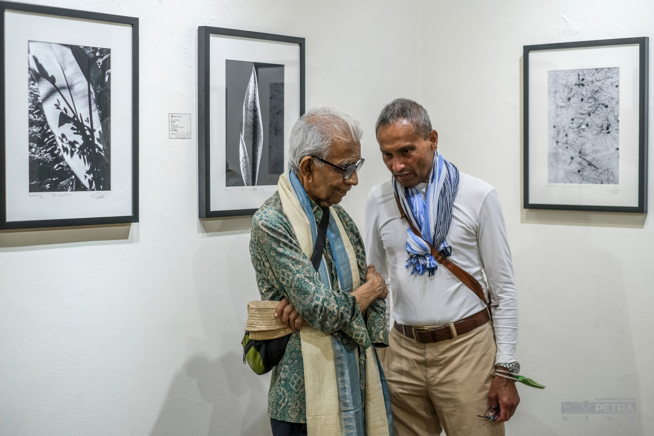 Celebrated photographer Eric Peris entertaining a guest during the exhibition. – ABDUL RAZAK LATIF/The Vibes pic