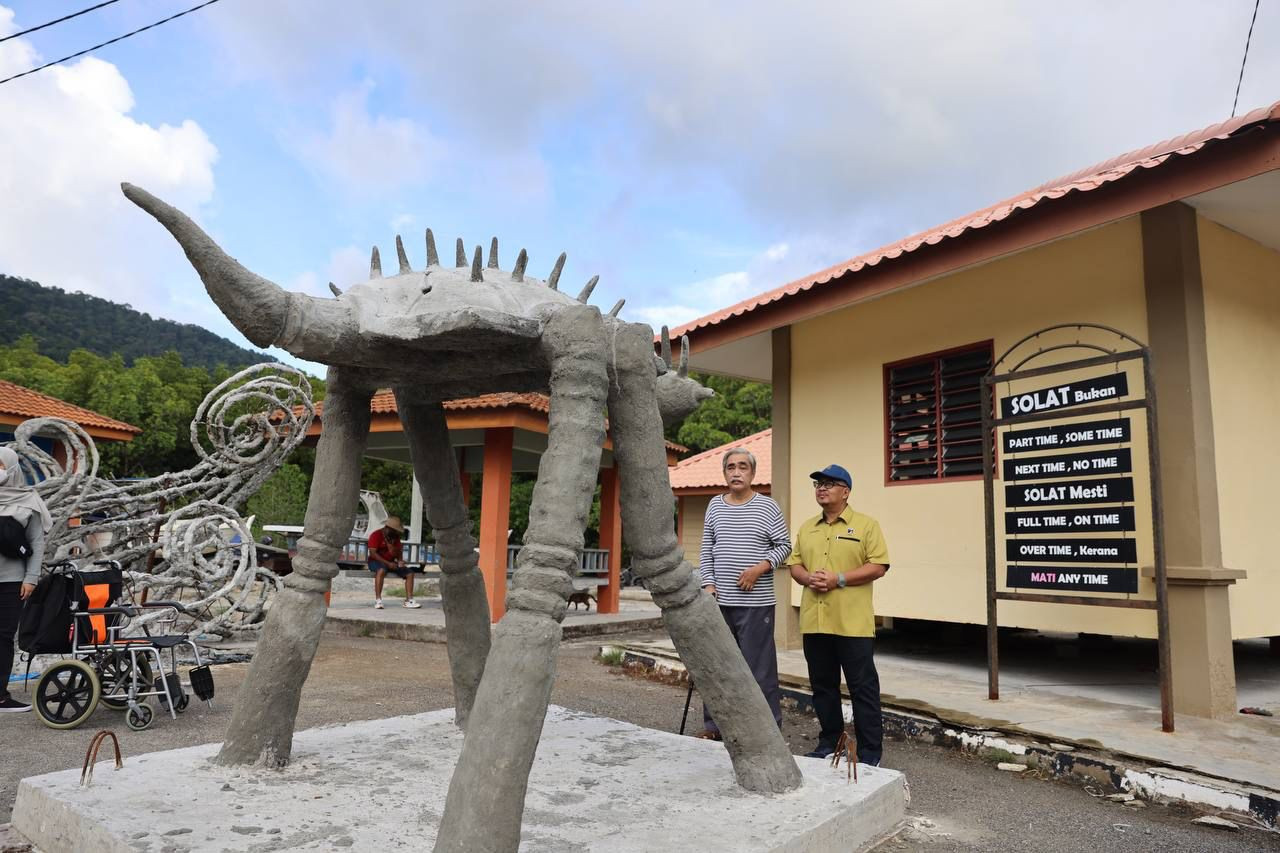 Nasaruddin (right) admiring the unique sculptures at Pengkalan Kubang Badak. – Pic courtesy of Lada