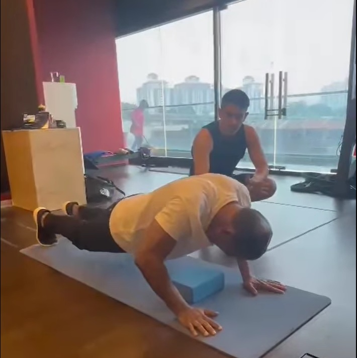 Saravanan doing push-ups with the help of his trainer. – Facebook pic, September 6, 2023