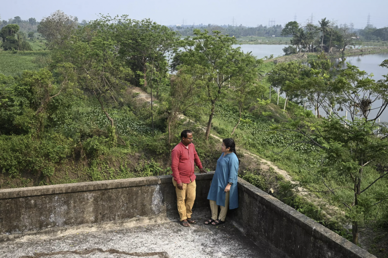 Environmental researcher Dhruba Das Gupta talks with fish farmer Sujit Mondal, who says pollution has hurt production. – AFP pic