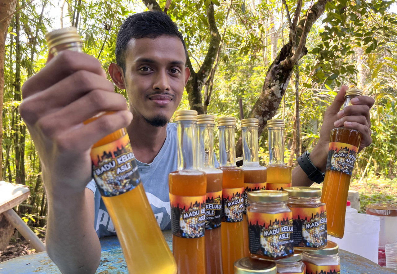 Zolkefli with the honey he harvested from the beehives. – Bernama pic