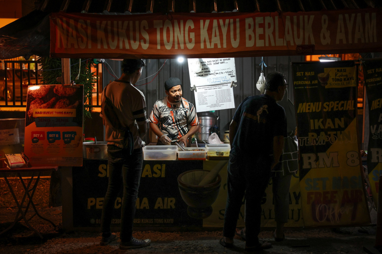 Suhaimi serving customers looking for sahur food early this morning. One customer said that more food stalls should operate at midnight to give people more choices for sahur. – Bernama pic