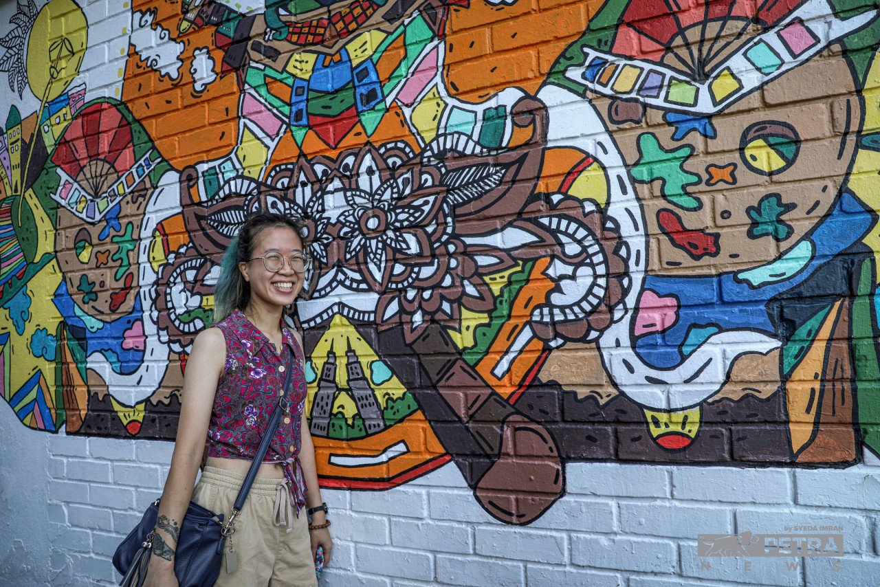 Ellie standing in front of the mural titled Fantasy Malaysia. – SYEDA IMRAN/The Vibes pic