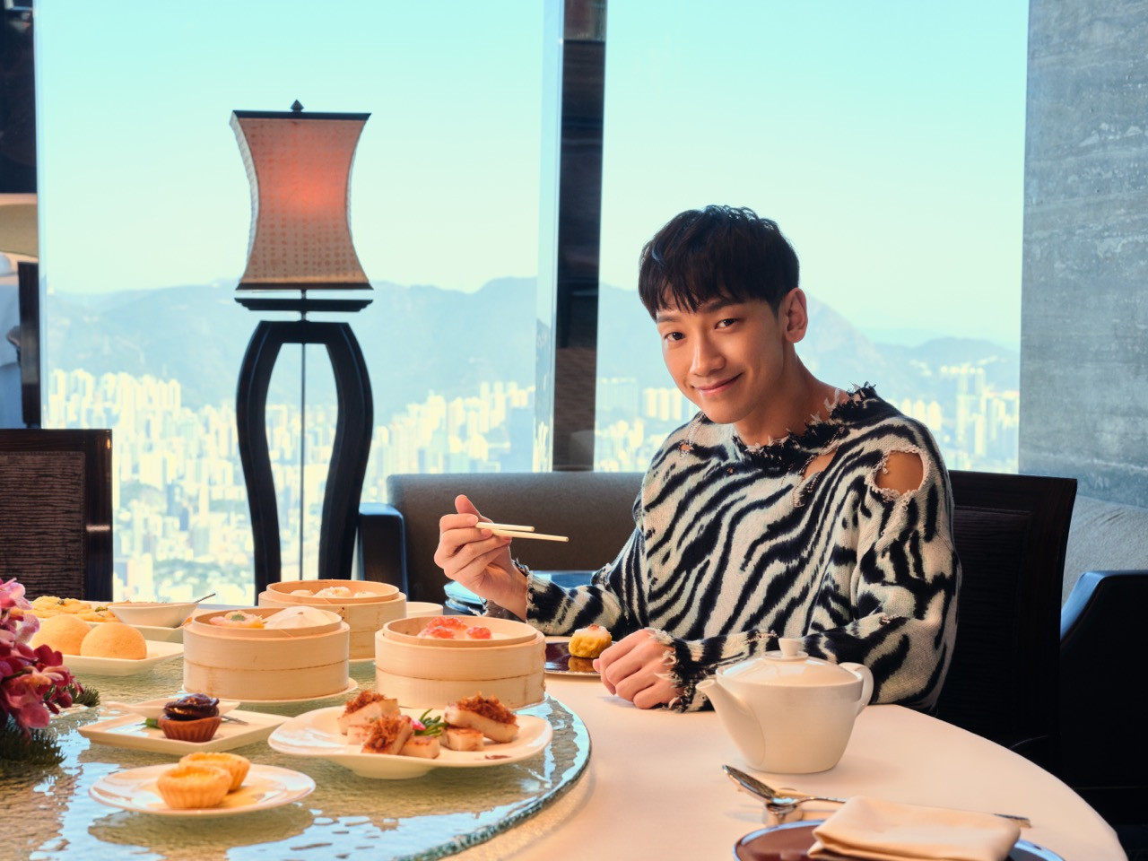 On the first stop of his trip, Rain enjoys delectable dim sum and a spectacular view of Hong Kong at a Michelin Cantonese restaurant. – Pic courtesy of HKTB