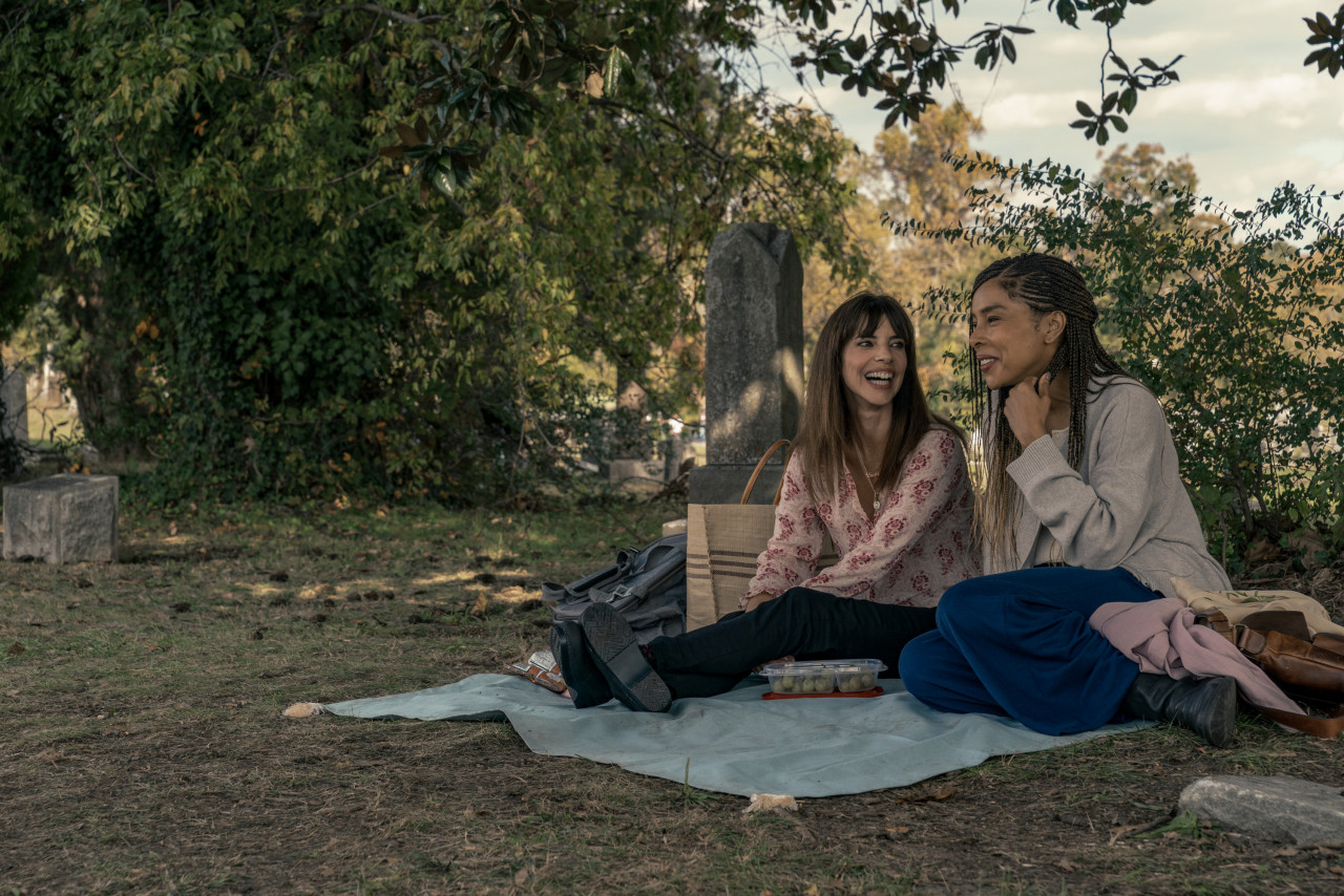 Lucia (Maribel Verdú) and Kiera (Sophie Okonedo) are both curiously drawn to the odd spectacle of these two men having to literally put their father into the ground. – Pic courtesy Apple TV+