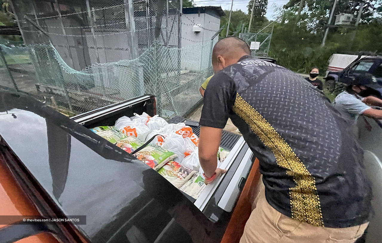 Benny Romee checks on food items prior to their distribution. – JASON SANTOS/The Vibes pic, August 29, 2021