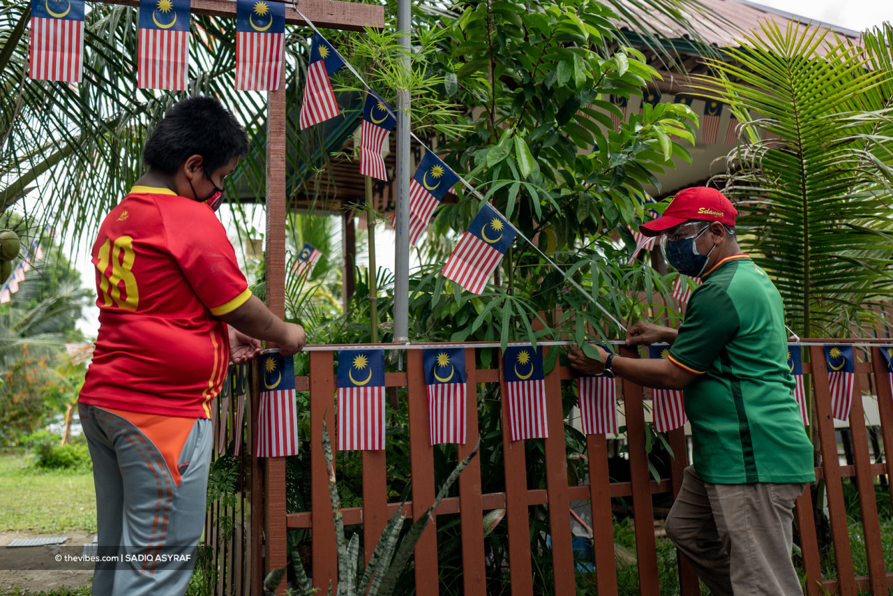 Members of the Block 40 community lending a hand in raising the Malaysian flag and decorating their community garden area. – SADIQ ASYRAF/The Vibes pic, August 31, 2021
