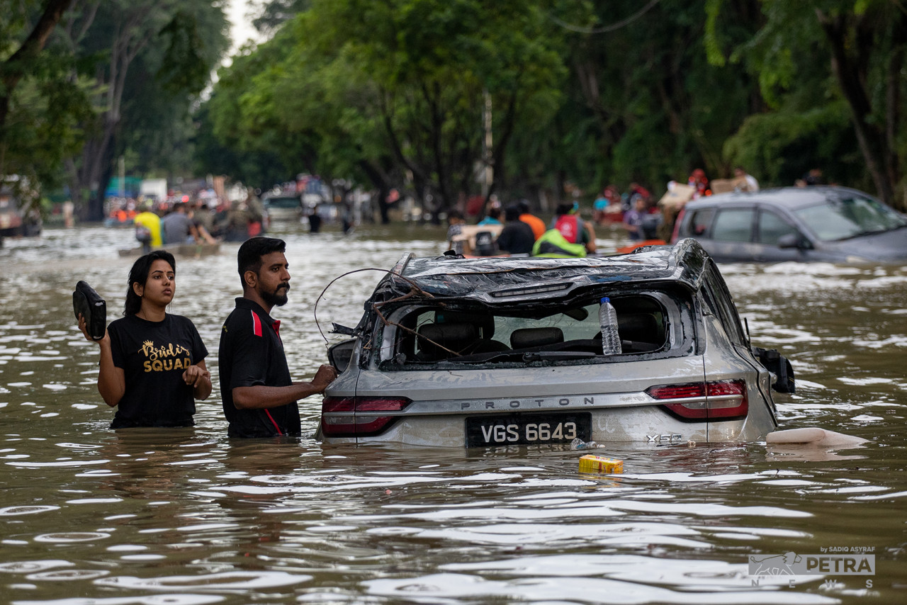 This couple can only hope and pray that their brand new car, now waterlogged and filthy, will still work once the waters recede. – SADIQ ASYRAF/The Vibes pic, December 22, 2021