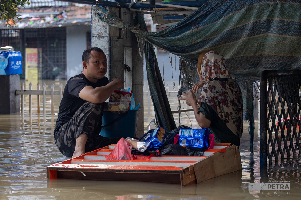 Taman Sri Muda residents' new normal is having a meal or two while surrounded by floodwaters. – SADIQ ASYRAF/The Vibes pic, December 22, 2021