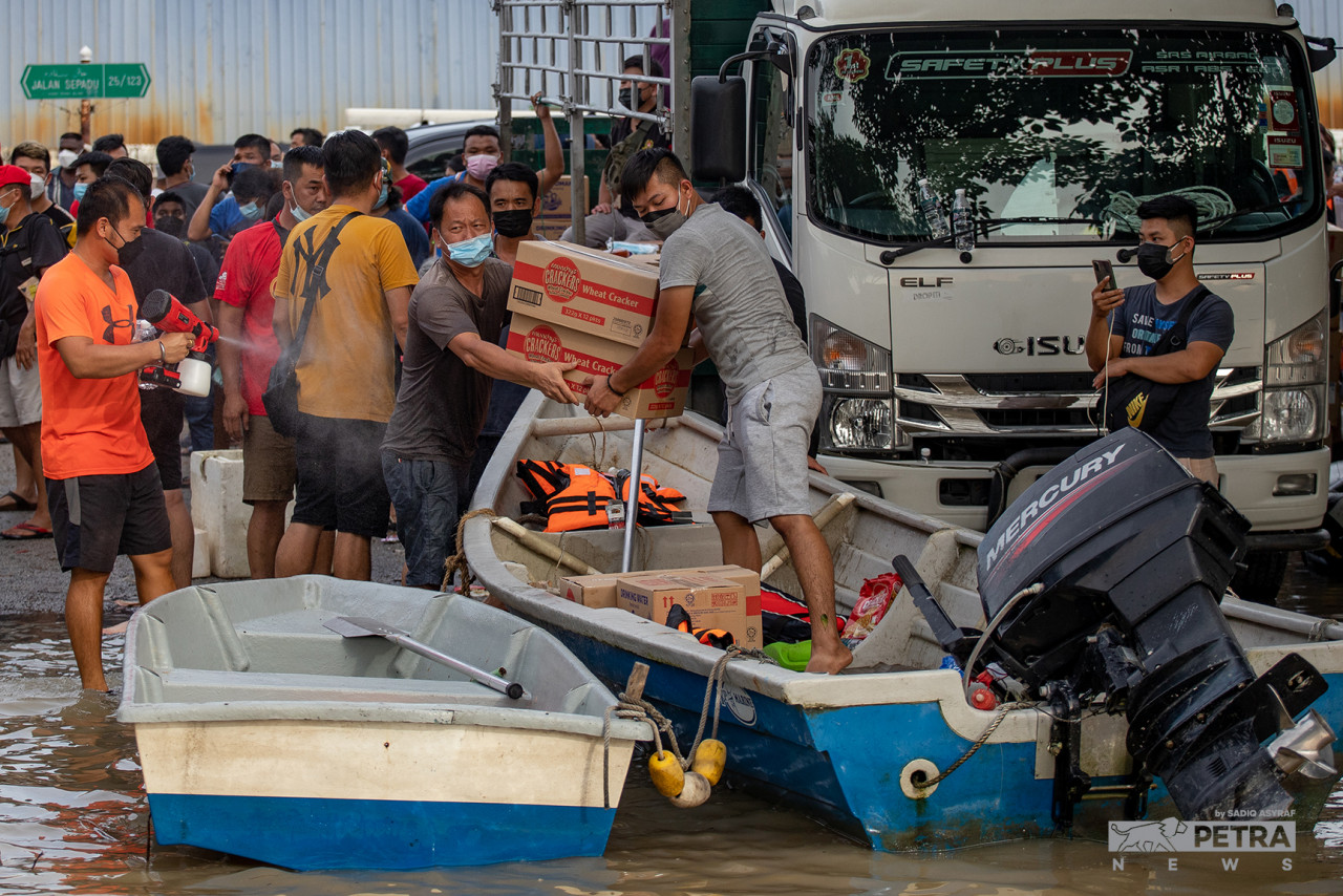 Several good Samaritans providing daily necessities and food to the residents of Taman Sri Muda. – SADIQ ASYRAF/The Vibes pic, December 22, 2021