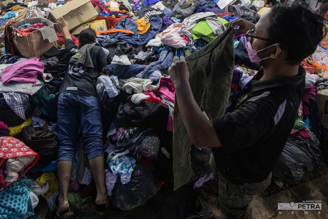 Mounds of clothes donated by the public give the residents of Taman Sri Nanding the opportunity to change into clean clothes. – SAIRIEN NAFIS/The Vibes pic, December 25, 2021