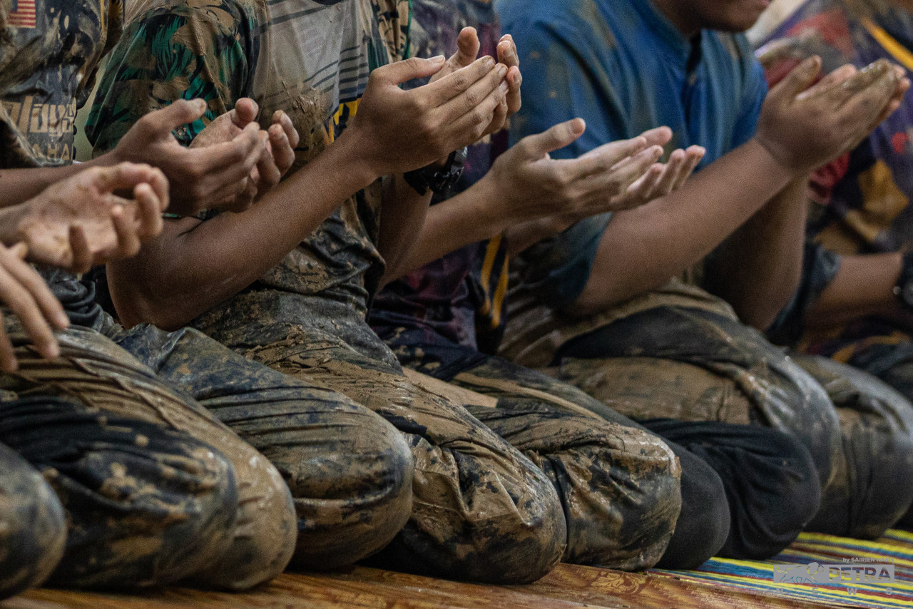 Volunteers comprising Madrasah Tahfiz Miftahul Ulum students pray during their break after helping clean houses hit by the massive floods in Hulu Langat. – SAIRIEN NAFIS/The Vibes pic, December 25, 2021