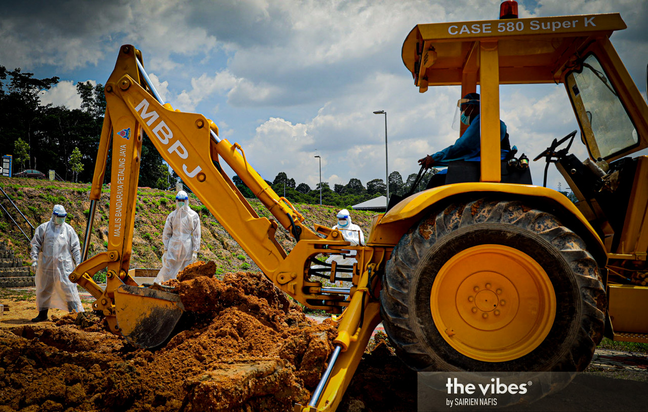 An excavator is used to fill a grave at the Kota Damansara Muslim cemetery. – The Vibes pic, February 4, 2021