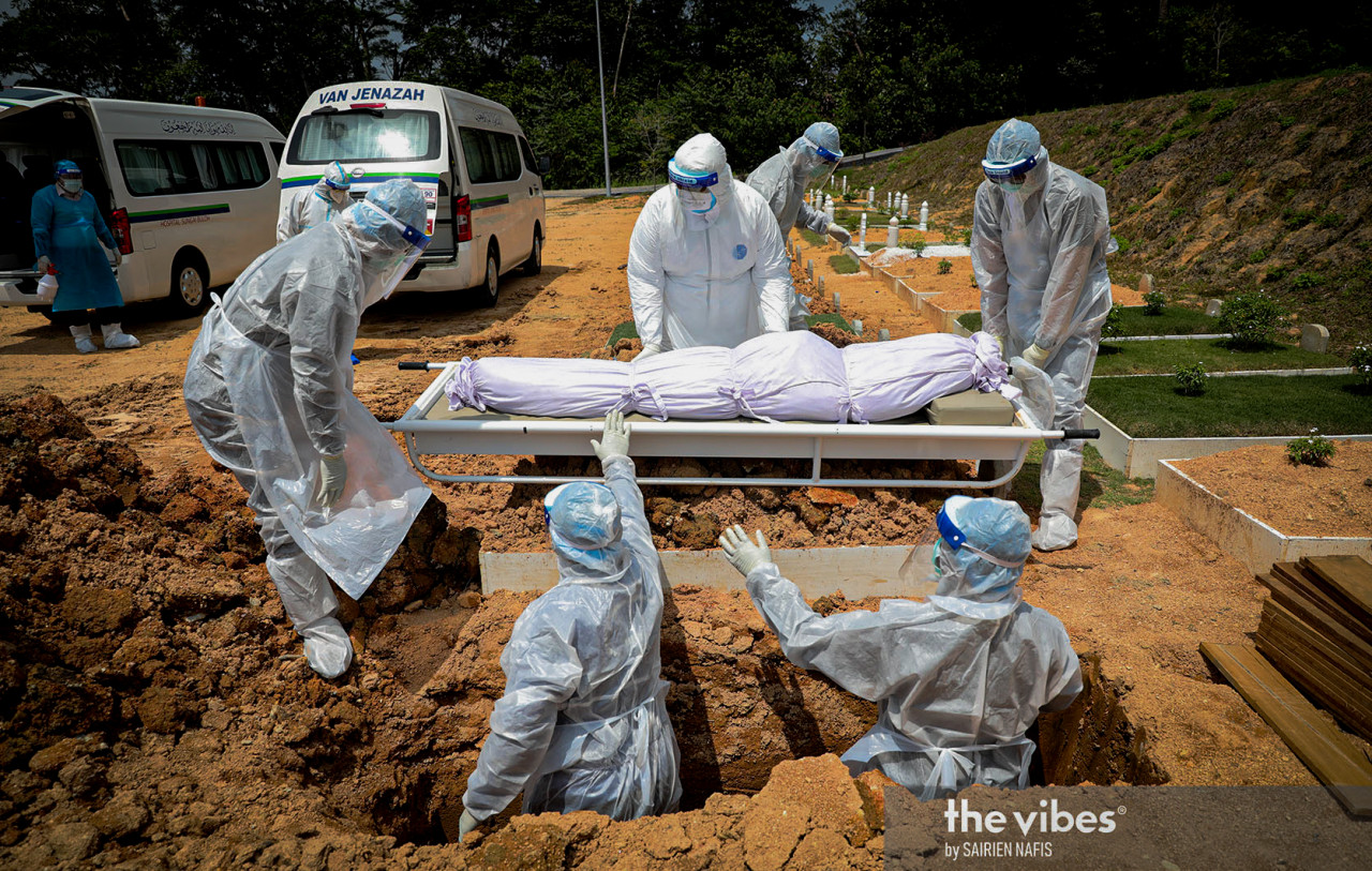 PJ City Council personnel readying to lower a body into a grave at the Kota Damansara Muslim cemetery. – The Vibes pic, February 4, 2021