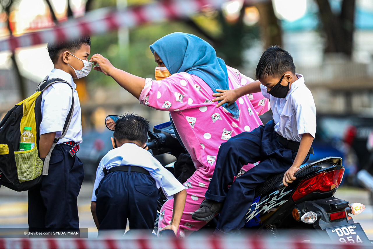 As part of the 'new normal', a mother checks to make sure her three sons are wearing their face masks correctly. – SYEDA IMRAN/ The Vibes pic