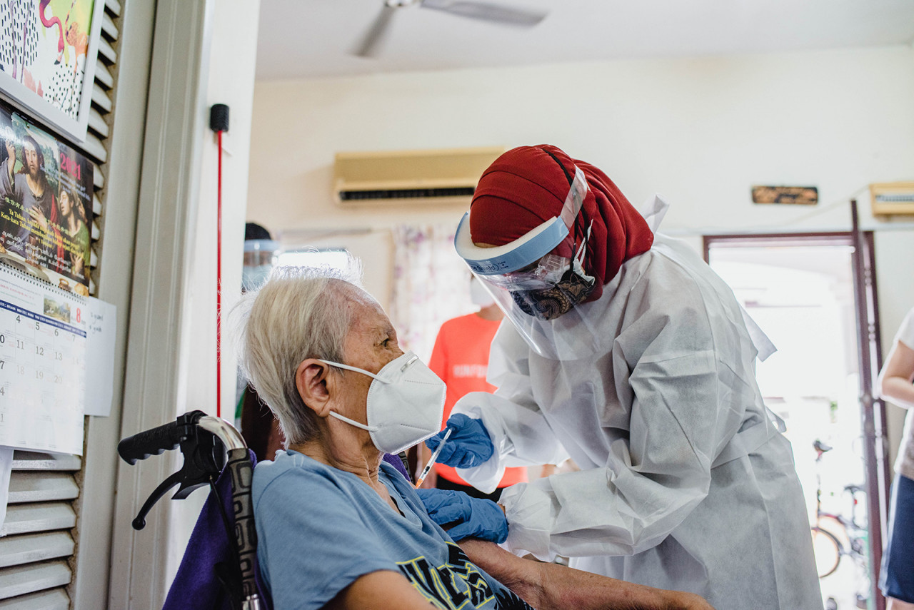 A MRCS volunteer administering the vaccine to a patient in her home. – Pic courtesy of Maxis