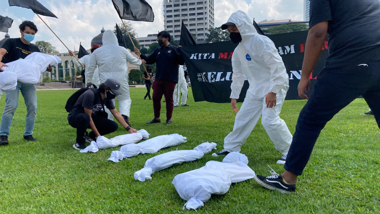Demonstrators arranging shrouded figures representing lives lost to Covid-19 and those who have committed suicide due to the pressures of the pandemic. – The Vibes pic, July 17, 2021
