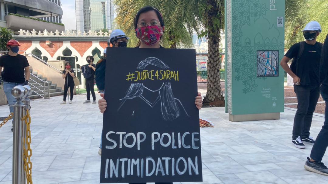Undi18 co-founder Qyira Yusri holds up a sign against police intimidation. – The Vibes pic, July 31, 2021