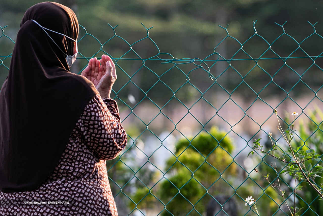 A woman prays for a loved one lost to Covid-19, outside the burial ground. – The Vibes pic, July 17, 2021