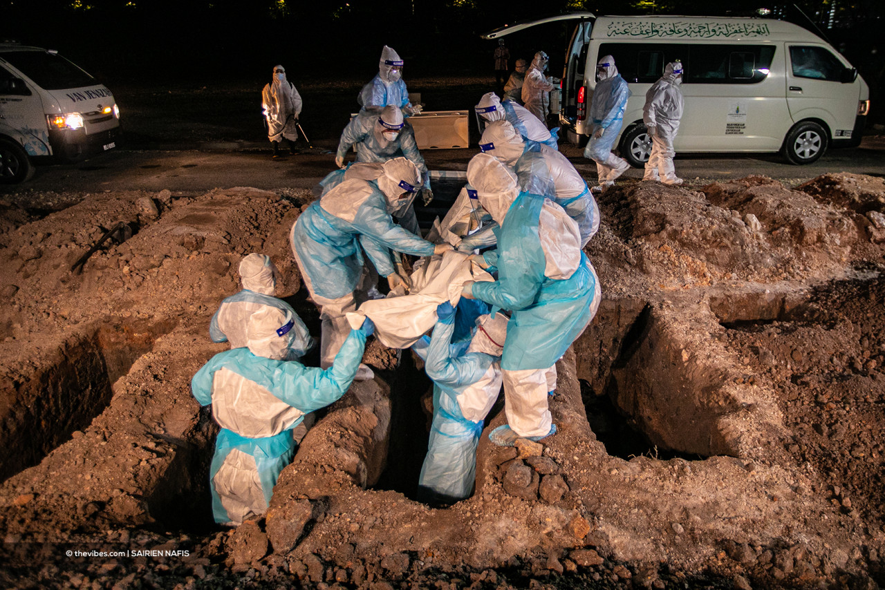 Frontliners lowering a body into a grave at the Section 21 Muslim cemetery yesterday. – The Vibes pic, July 17, 2021