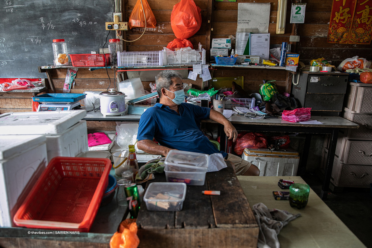 Seafood supplier Lim Gee Sing takes a breather while waiting for customers at his shop in Pasir Penambang. – The Vibes pic, June 6, 2021