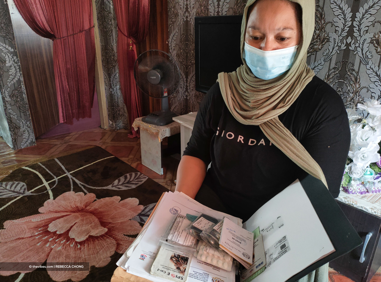 Iqmal’s mother, Normah Jattjo shows Iqmal’s medical file and the medication needed for his heart problem. – REBECCA CHONG/Vibes pic