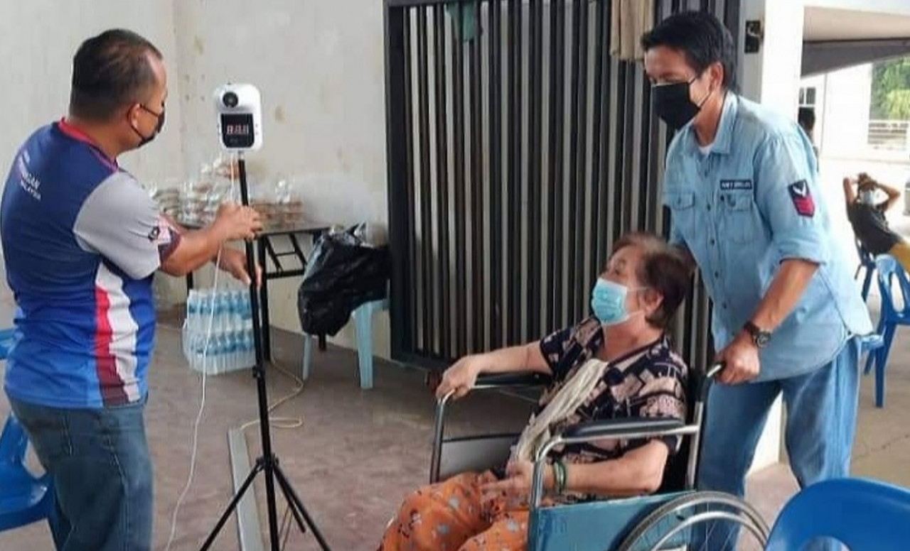 Telang Usan assemblyman Dennis Ngau pushes the wheelchair of a Covid-19 jab recipient at a clinic in rural northern Sarawak. – Dennis Ngau Facebook pic, June 19, 2021