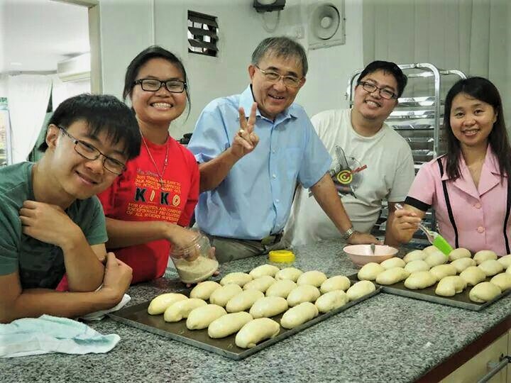 The late Cornelius Cardinal Sim in the company of youths at his bakery who have come to help him prepare dough for his Friday bakery ministry. – Pic courtesy of Regional Commission for Social Communication