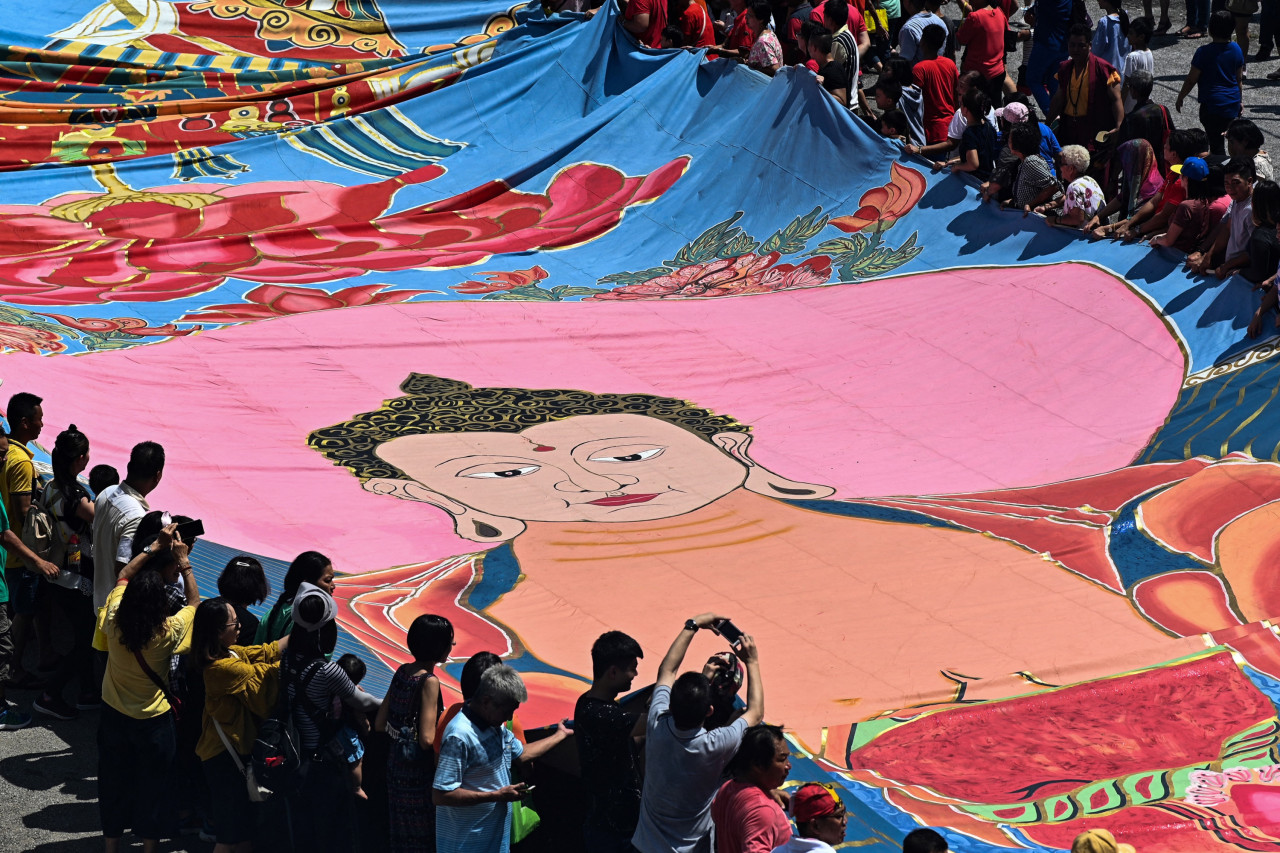 Buddhist devotees unfurl the same 196-foot-long sacred 'Thangka' at the Enlightened Heart Tibetan Buddhist temple on May 19, 2019. – AFP pic