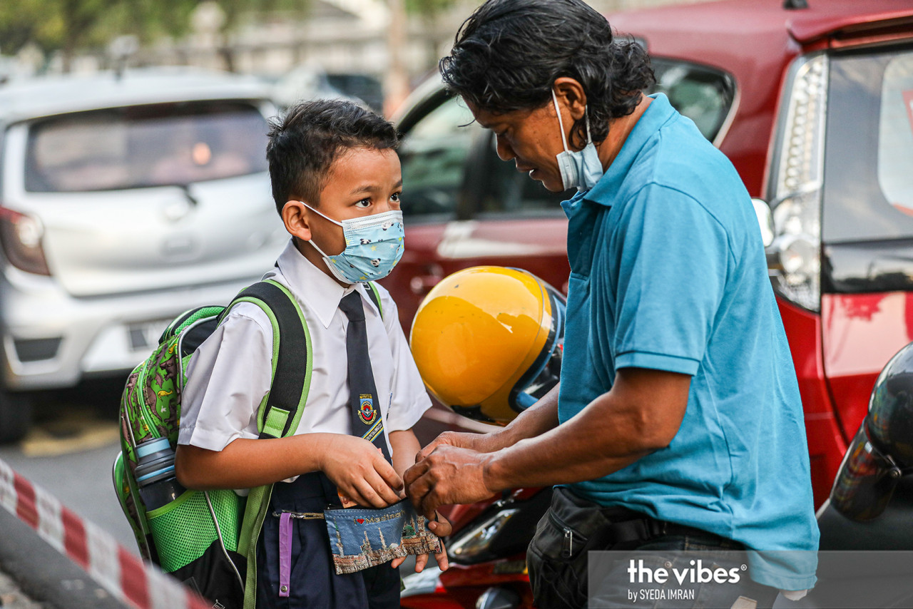 A father gives his son pocket money at SK Bandar Baru Sri Petaling 2. – SYEDA IMRAN/The Vibes pic, March 8, 2021