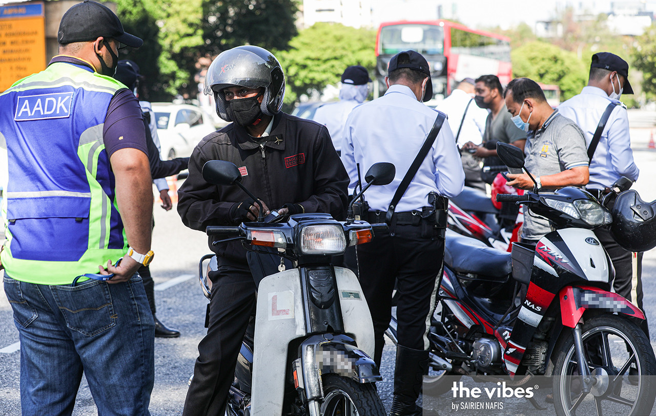 An AADK officer questioning a motorist during a joint operation at Jalan Ampang. – The Vibes file pic