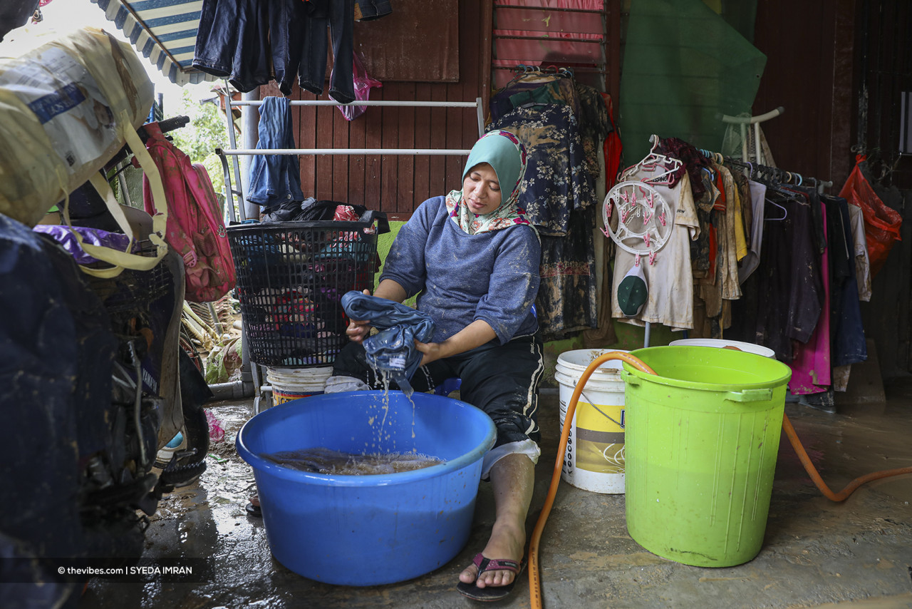 An Ampang Jaya resident washes dirty clothes after the floods. – SYEDA IMRAN/The Vibes pic, November 25, 2021