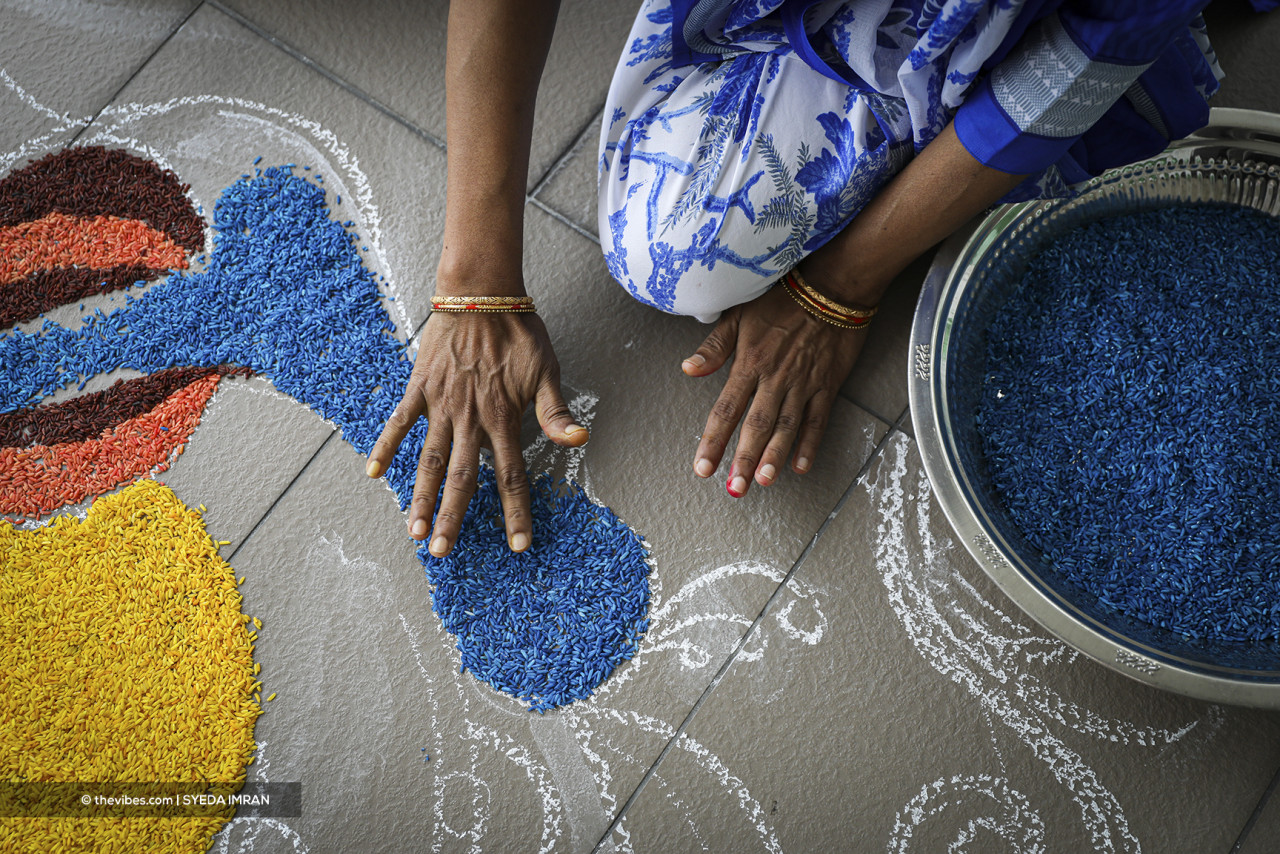 A skilled artist carefully fills in the lines of a kolam with the use of brightly coloured rice. – SYEDA IMRAN/The Vibes pic, November 4, 2021